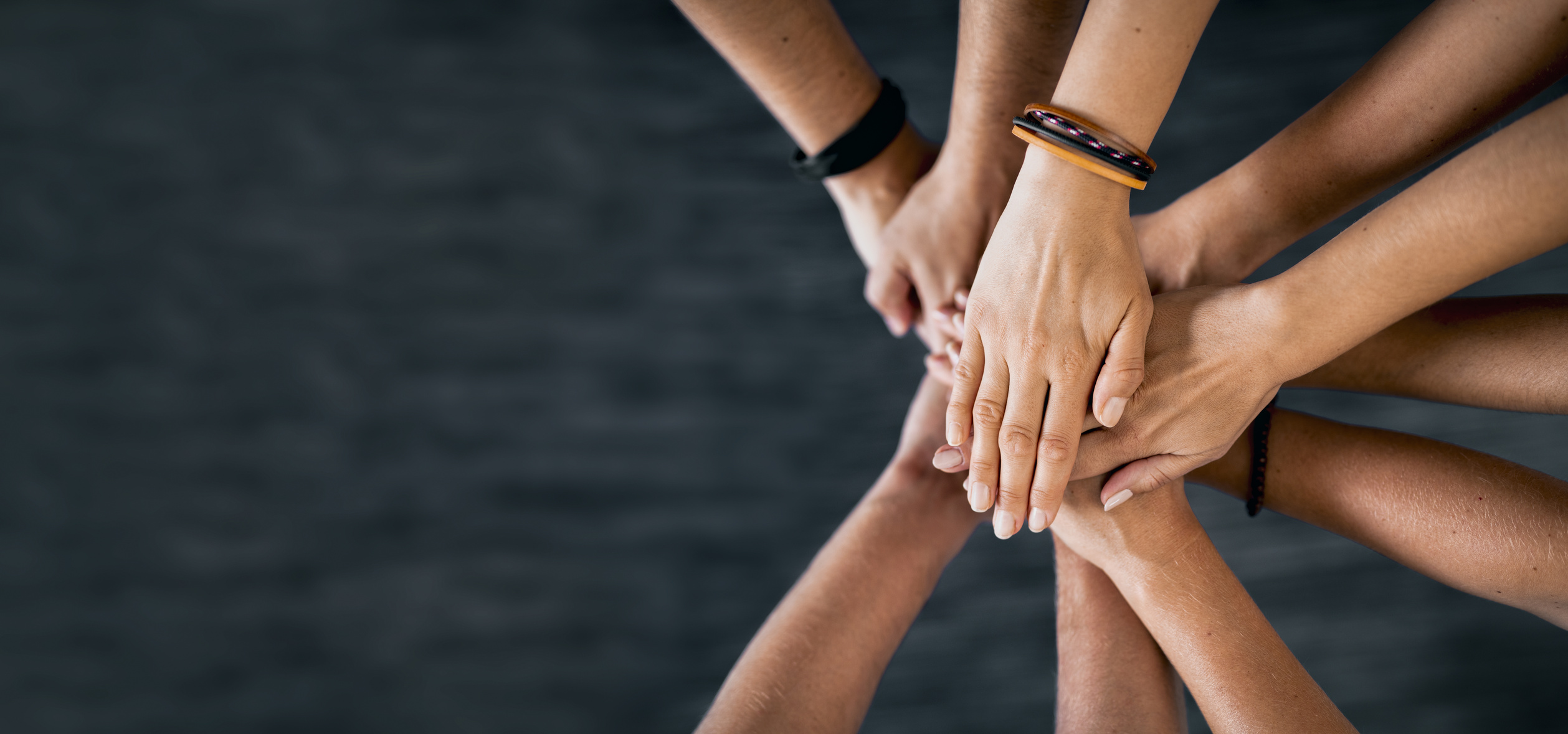 Top View of Hands Joining Together on Black Background